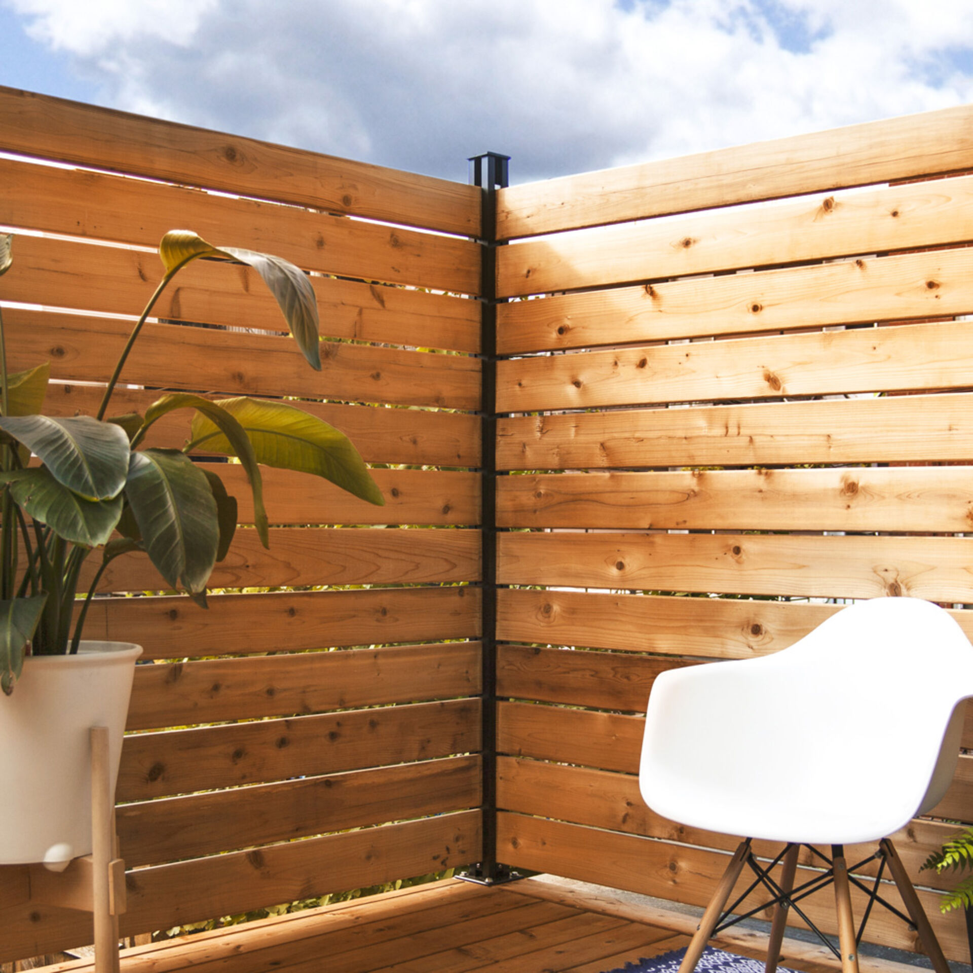 online_kitbphoto1 HOFT 72" Post Kit installed as a contemporary wood privacy fence for a patio, featuring horizontal cedar boards and durable black aluminum posts.